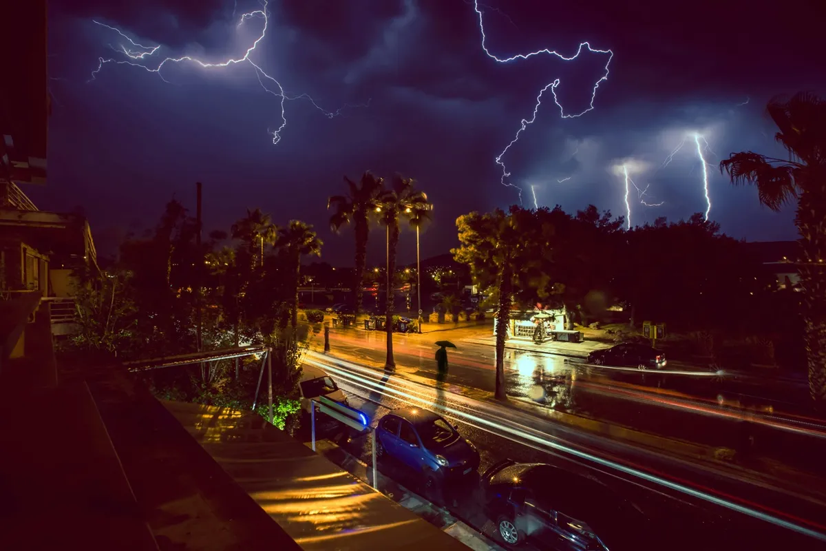 Storm with Lightnings over City Street at Night