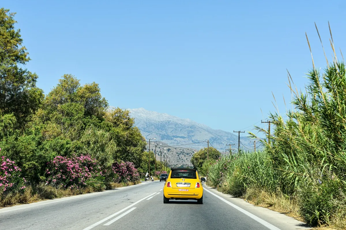 Yellow Car on Scenic Greek Road with Mountain View